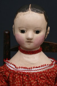 Savannah has a red coral bead necklace and a chemise trimmed in red tatting.