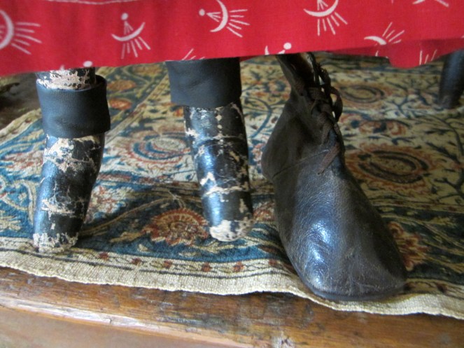 Here you can see the painted version on the doll and the real life child's boot side by side.  The ankles on this Izannah Walker doll have given way over time, with the painted fabric splitting near the ankle seam, where the leg is weaker.  I have conserved the legs by affixing thin bands of leather to the ankles, using rubber cement.  This holds the legs and feet together, but is a repair that can be removed without causing damage to the original antique surfaces beneath.