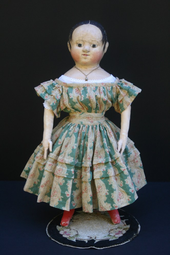 Anna #2 is shown here wearing her dress made from a very early c. 1830-1840 cotton gauze paisley print. The green, red, brown and ivory fabric is perfect for late fall and the upcoming Christmas season. The sleeves and skirt of the dress have graduated growth tucks.