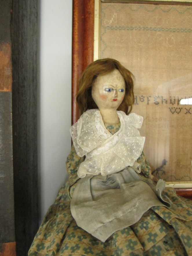 Her clothing was replaced in the mid-19th century.  She is currently wearing a dress that is made very much like those I make for my Izannahs.  The dress is made from a thin, gauzy cotton with a Prussian blue print.  It fastens with a glass button and brass hook.