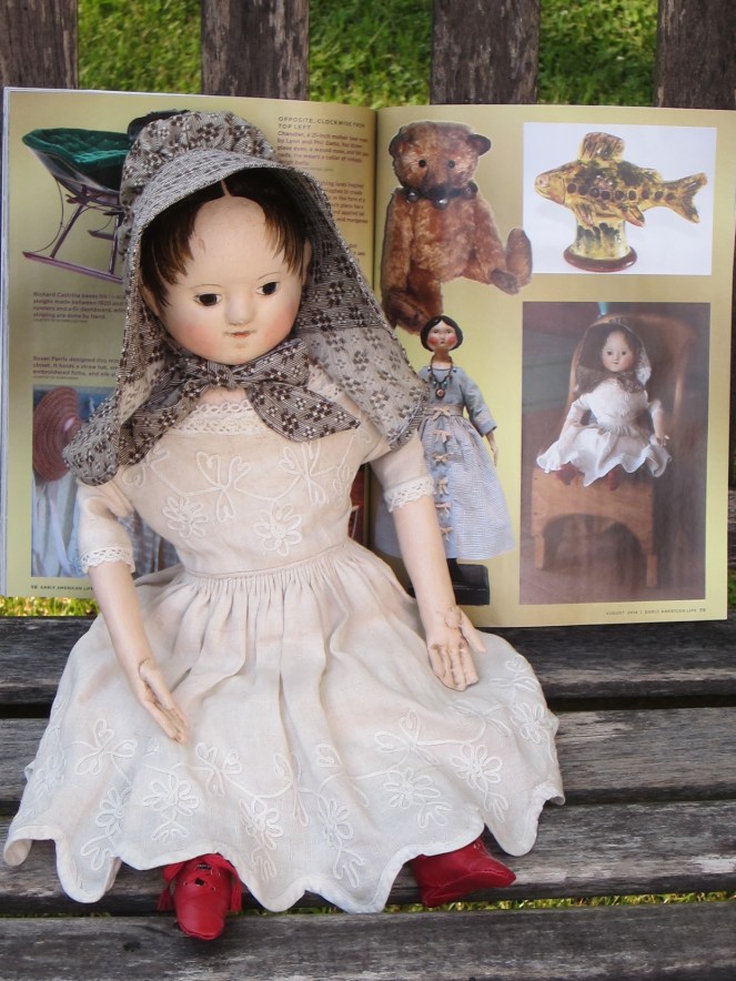 My doll posing with her photo in the Early American Life Craftsman Directory.