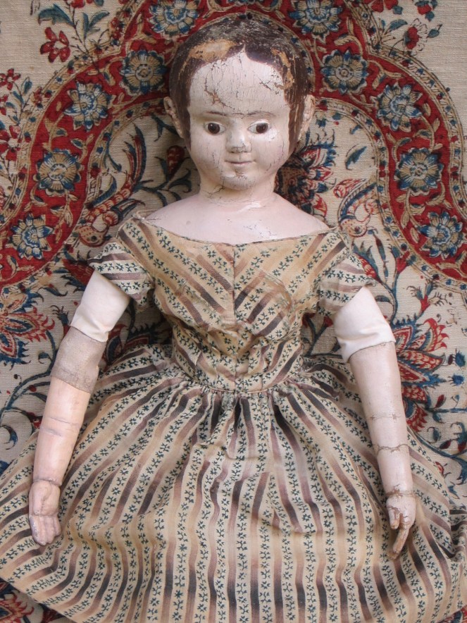 After restoration.  The doll's dress is made from very thin fragile wool fabric that has never been washed. It's orogonal long sleeves were cut off at some point. I did some very minor sewing repairs on the dress and washed all of her under garments with museum conservation cleaning products.  The change in color is very subtle. These photos were taken before the doll was seen by her owner. After the owner had a chance to see the replaced arm and replaced antique linen upper arm covering, we decided to "age" the fabric and arm more.