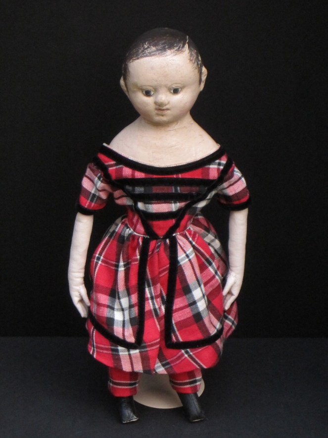 17 inch tall Andrew, dressed in a split skirt red and black plaid dress with black velvet trim, matching breeches, antique linen chemise and black and red painted boots.