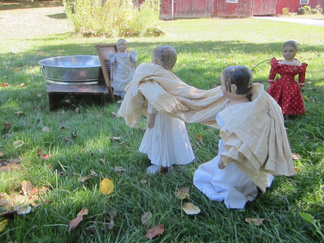 Hannah and Isabeau carry the party dress out to the wash tub.