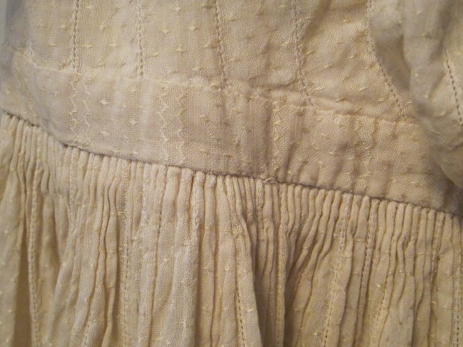The dress fabric is a woven white on white cotton that has turned to a lovely pale ivory over time. All of the long seams are machine sewn, with the detail work, such as this tiny cartridge pleating done by hand.